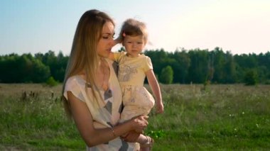 Anne Holding çocuk ellerinde. Parmakla gösterilen bir şey çocuk için söz. Yaz nehir Gölü sabah güneşli gün mavi gökyüzü. Ağır çekim 30p 0,5 60 p