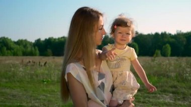 Anne Holding çocuk ellerinde. Parmakla gösterilen bir şey çocuk için söz. Yaz nehir Gölü sabah güneşli gün mavi gökyüzü. Ağır çekim 30p 0,5 60 p