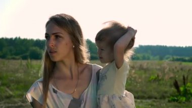 Anne Holding çocuk ellerinde. Parmakla gösterilen bir şey çocuk için söz. Yaz nehir Gölü sabah güneşli gün mavi gökyüzü. Ağır çekim 30p 0,5 60 p