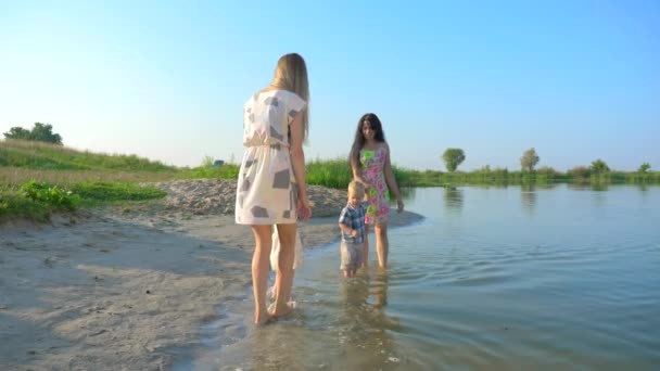つの若い美しい母親は歩くし 子供たちと水遊び 夏の川朝晴れた青い空 スローモーション — ストック動画