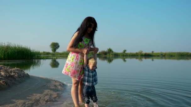 Dos Madres Hermosas Jóvenes Caminan Juegan Agua Con Sus Hijos — Vídeo de stock