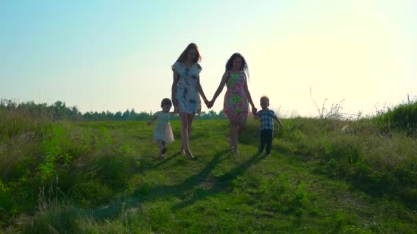 Dos Madres Guapas Jóvenes Caminando Con Niños Por Colina Summer — Vídeo de stock