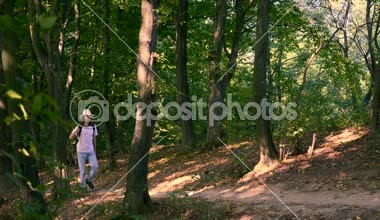  Sırt çantası ve sopa ile ahşap beyaz adam turist Hiking. Geniş Shot yavaş hareket 4k