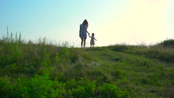 丘の下の子供と若い美しい母散歩 夏の朝晴れた青い空 スローモーション — ストック動画