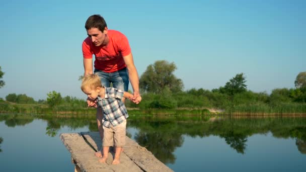 Jovem Bonito Caminhando Com Bonito Criança Segurando Mãos Summer River — Vídeo de Stock