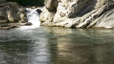 Atış kaydırma. Susuz adamın içme suyu dağ nehir. Siyah pelerin Hood baca şapkası ile. Yaz güneşli gün. 4 k yavaş hareket