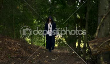 Siyah pelerin palto Hood ile Ortaçağ gizemli aylak adam ormanda yürür. Misyoner Keşiş Dağı ormanda