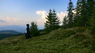 Monk misyoner uzak seyahat toprakları. Gizemli Wanderer dağın tepesinde seyahat. Siyah pelerin ceket Hood ile adam