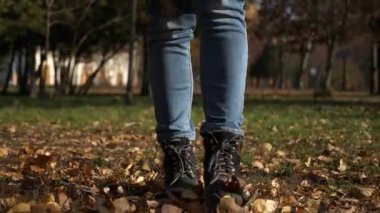4k 60p yakın çekim kadın ayak sarı parkta bırakır. Sonbahar güneşli gün