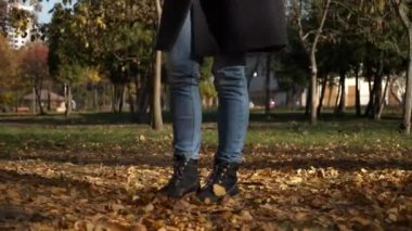 4k 60p yakın çekim kadın ayak sarı parkta bırakır. Sonbahar güneşli gün