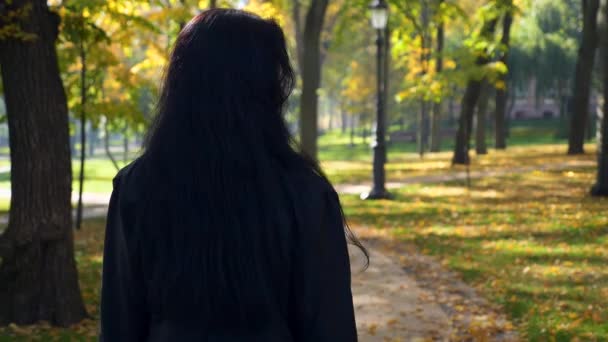 Kamera Követi Gyönyörű Komoly Lány Néz Vissza Mosolyog Gyaloglás Városligetben — Stock videók