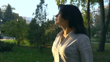 Portre günbatımı gülümsüyor izlerken güzel mutlu kadın. Sonbahar Park altın saat akşam