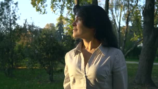 肖像美丽的快乐的女人看日落微笑 秋天晚上黄金时间在公园里 — 图库视频影像