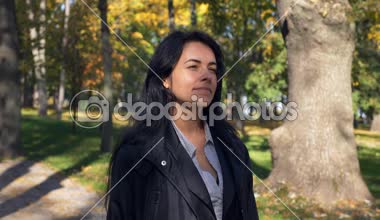 Ağaçlara arıyorum şehir Park'ta yürüyordunuz romantik güzel kız bırakır. Sonbahar sabahı güneşli. Yavaş hareket 4k 60 fps