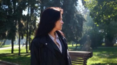Ciddi güzel kız yürüyen Şehir Parkı ve düşünme. Sonbahar güneşli bir günde Şehir Parkı. Sabah güneş ışığı. Ağır çekim 60 fps