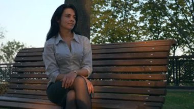 İş kadını tezgah Settle.Thinking ve zevk iş günü sonra dinlenme. Tarihi gecikme. Şehirde sonbahar güneşli akşam Sunset Park altın saat