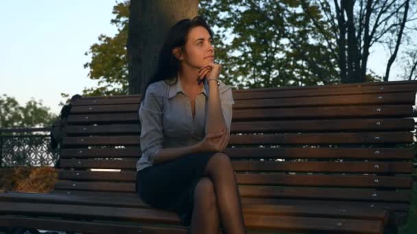 商业妇女休息一天后在板凳上的设置 思考和享受 日期延迟 秋天阳光明媚的夜晚日落在城市公园黄金时间 — 图库视频影像