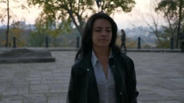 İşten sonra güzel kız akşam alacakaranlık parkta yürüyor. Sonbahar akşam şehir arka plan. 4 k yavaş hareket 60 fps