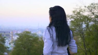 Güzel kız ayakta ve şehir parkı tepe üzerinde düşünme. (Sabah) gökyüzü yukarıda Cityscape akşam arıyorum. Yaz sonbahar sezonu