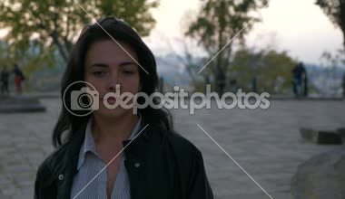 İşten sonra güzel kız akşam alacakaranlık parkta yürüyor. Sonbahar akşam şehir arka plan. 4 k yavaş hareket 60 fps