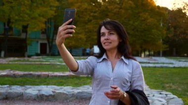 Turist Selfie resimleri ile Smartphone tarihi bölgesinde alarak kız güzel. Harabeleri antik uygarlık kalıntıları. Sonbahar akşam gün batımı. Altın saat mavi saat 4k yavaş 60fps