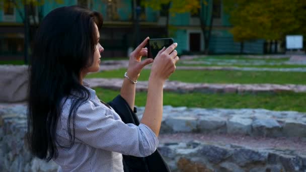 観光歴史地域でスマート フォンで写真を撮る美しい少女 古代文明の遺跡遺跡 秋の夕日 黄金の青い時間 スローモーション Fps — ストック動画