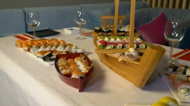 Lezzetli geleneksel Japon suşi ruloları ve Nigiri tabakları servis edilir. Wasabi sosu. Güzel dekore edilmiş suşi gemisi. Restoranda ayrılmış bir masa var. Kutlama için yemek servisi.
