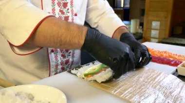 Close-up Hands Making Long Sushi Rolls Nigiri. Japanese Cuisine Master Chef Cook Preparing Food at Restaurant. Ingredients For Cooking Dish Meal