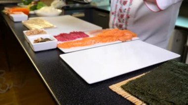 Close-up Hands Making Long Sushi Rolls Nigiri. Japanese Cuisine Master Chef Cook Preparing Food at Restaurant. Ingredients For Cooking Dish Meal