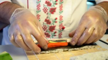 Close-up Hands Making Long Sushi Rolls Nigiri. Japanese Cuisine Master Chef Cook Preparing Food at Restaurant. Ingredients For Cooking Dish Meal