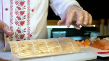 Close-up Hands Making Long Sushi Rolls Nigiri. Japanese Cuisine Master Chef Cook Preparing Food at Restaurant. Ingredients For Cooking Dish Meal