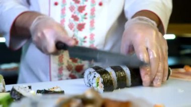 Close-up Hands Making Long Sushi Rolls Nigiri. Japanese Cuisine Master Chef Cook Preparing Food at Restaurant. Ingredients For Cooking Dish Meal