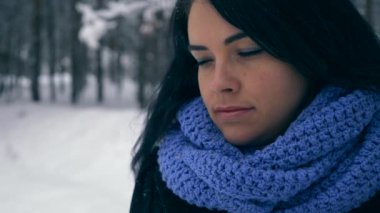 Hüzünlü güzel kız kış ormanda kar yağışı sırasında yürüyüş düşünüyorum. Doğa tatilde. Soğuk Frost hava. Kar ağaçlar ahşap kaplı. Ağır çekim 60 fps
