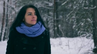 Hüzünlü güzel kız kış ormanda kar yağışı sırasında yürüyüş düşünüyorum. Doğa tatilde. Soğuk Frost hava. Kar ağaçlar ahşap kaplı. Ağır çekim 60 fps