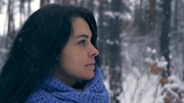 Portre oldukça ciddi kız düşünme ve gökyüzü üzerine arıyorum. Kış tatil tatil. Kar yağışı sırasında kış orman. Frost hava kar ağaçlar ahşap kaplı. Ağır çekim 60 fps