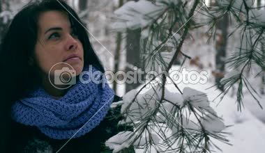 Portre oldukça ciddi kız düşünme ve gökyüzü üzerine arıyorum. Kış tatil tatil. Kar yağışı sırasında kış orman. Frost hava kar ağaçlar ahşap kaplı. Ağır çekim 60 fps