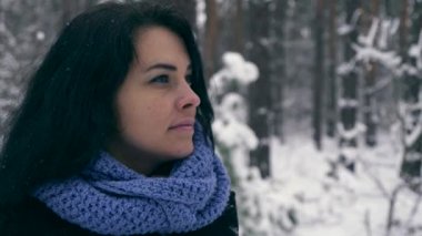 Portre oldukça ciddi kız düşünme ve gökyüzü üzerine arıyorum. Kış tatil tatil. Kar yağışı sırasında kış orman. Frost hava kar ağaçlar ahşap kaplı. Ağır çekim 60 fps