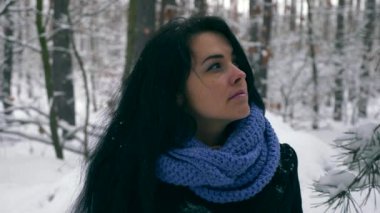 Portre oldukça ciddi kız düşünme ve gökyüzü üzerine arıyorum. Kış tatil tatil. Kar yağışı sırasında kış orman. Frost hava kar ağaçlar ahşap kaplı. Ağır çekim 60 fps