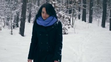 Ciddi güzel kız kış ormanda kar yağışı sırasında zevk doğa yürüyüşleri. Kış tatillerinde seyahat hiking. Frost hava kar ağaçlar ahşap kaplı. Ağır çekim 60 fps