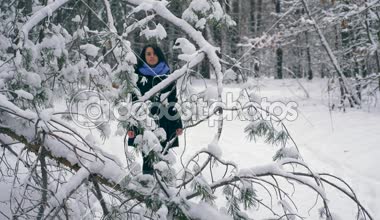 Ciddi güzel kız kış ormanda kar yağışı sırasında zevk doğa yürüyüşleri. Kış tatillerinde seyahat hiking. Frost hava kar ağaçlar ahşap kaplı. Ağır çekim 60 fps
