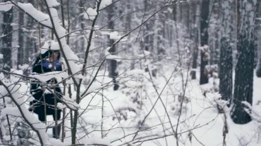 Ciddi güzel kız kış ormanda kar yağışı sırasında zevk doğa yürüyüşleri. Kış tatillerinde seyahat hiking. Frost hava kar ağaçlar ahşap kaplı. Ağır çekim 60 fps