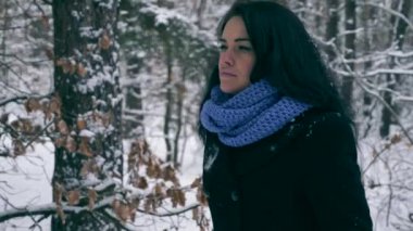 Ciddi güzel kız kış ormanda kar yağışı sırasında zevk doğa yürüyüşleri. Kış tatillerinde seyahat hiking. Frost hava kar ağaçlar ahşap kaplı. Ağır çekim 60 fps