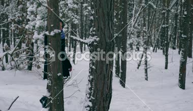 Ciddi güzel kız kış ormanda kar yağışı sırasında zevk doğa yürüyüşleri. Kış tatillerinde seyahat hiking. Frost hava kar ağaçlar ahşap kaplı. Ağır çekim 60 fps