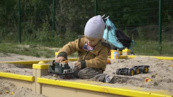 Serious Cute Child Juega Solo Con Juguete Roto Sandbox Niño — Vídeos de Stock