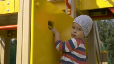 Neşeli mutlu çocuk çocuk oyun alanı üzerinde merdiven yalnız çalış üzerinde tırmanıyor. Ülke yaşam. Bahar yaz sonbahar güneşli gün