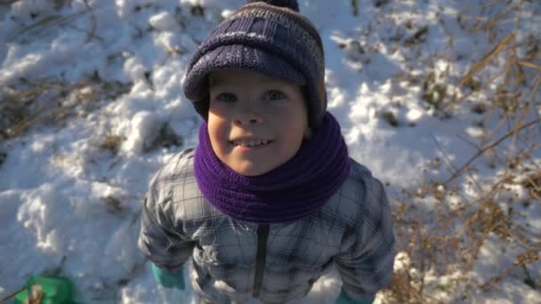 快乐的孩子在相机中微笑 可爱的男孩在温暖的冬季服装户外在雪的天气 寒假晴天 — 图库视频影像