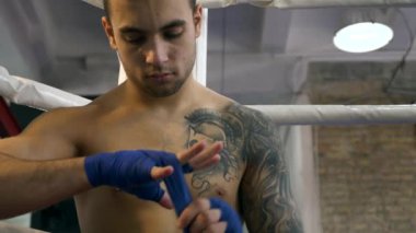 Ağır çekim yakın çekim portre boksör Fighter koyarak el sarar süre oturan Boks ringi üzerinde