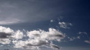 Hızlandırılmış beyaz kabarık bulutlar üzerinde koyu mavi gökyüzü