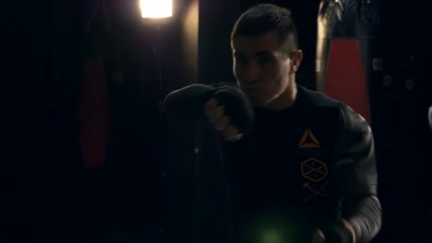 特写泰战斗机拳击手激烈扔在相机与激烈的外观在他的脸上 在健身房的黑暗训练 — 图库视频影像