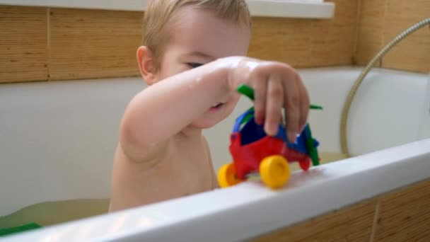 Fröhliches Fröhliches Kind Spielt Lächelnd Mit Spielzeug Wasser Der Badewanne — Stockvideo